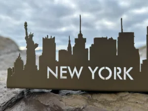 Silueta metálica Nueva York con Estatua de la Libertad sobre roca