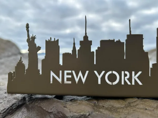 Silueta metálica Nueva York con Estatua de la Libertad sobre roca